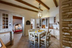 eine Küche mit einem Tisch und Stühlen sowie ein Esszimmer in der Unterkunft Castello Villa Daphnes - Private Pool & Whirlpool in Dhafnés