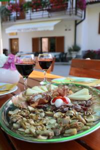 a plate of food on a table with two glasses of wine at Farm Stay Pri Cepčovih in Golac +32 photos