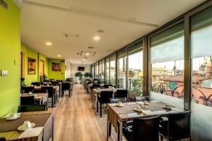 un ristorante con tavoli, sedie e finestre di Trevi Collection Hotel - Gruppo Trevi Hotels a Roma