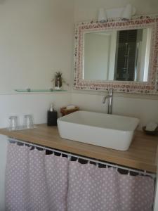a bathroom with a white sink and a mirror at Chambres d'hôtes de Ty Guen in Trédarzec