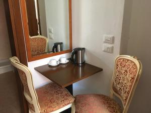 Habitación con mesa, 2 sillas y espejo. en Casa Dolce, en Venecia