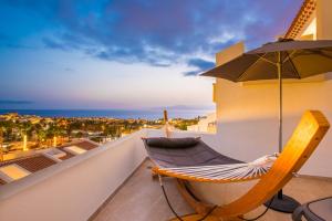 a hammock on a balcony with a view of the ocean at Haciendas Village Tenerife in Adeje