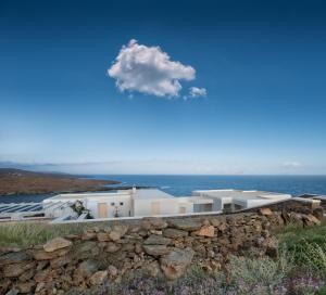 a white building on a hill with the ocean at Astrini in Kithnos