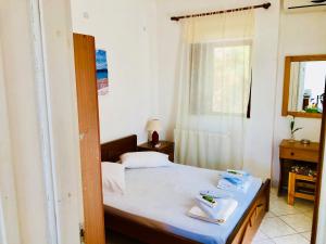 a small bedroom with a bed and a window at Rooms Olympia in Gialiskari