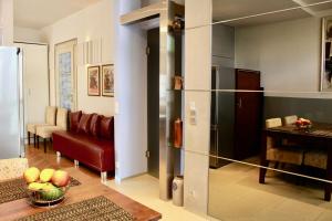 クラクフにあるAlder Apartmentsのリビングルーム(赤いソファ、冷蔵庫付)