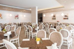 een kamer vol stoelen, tafels en tafels bij Grenada Hotel in Sunny Beach