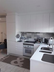 a white kitchen with white cabinets and a sink at ESTRELLA DEL MAR Amazing Loft Casa Cosy in La Playa de Arguineguín