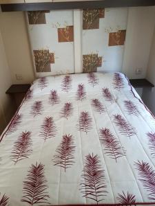 レ・マトゥにあるMobil Home 3 CH - 2 SDB - Tout Confortの白い毛布と植物のベッド