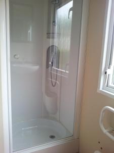 レ・マトゥにあるMobil Home 3 CH - 2 SDB - Tout Confortのバスルーム(ガラスドア付きのシャワー付)