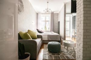 ワルシャワにあるoompH Koszyki Luxurious Apartmentsのリビングルーム(ソファ、ベッド付)