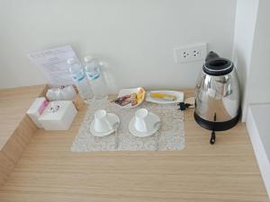 a table with two cups and a coffee maker on it at Pua De View Boutique Resort in Pua