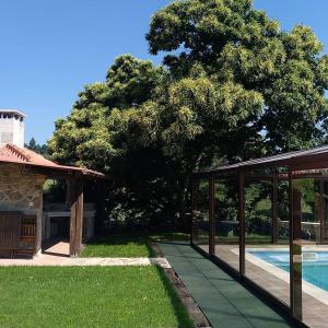 ア・エストラーダにあるCasa da Pastoraのプール横の木とパビリオンのある家