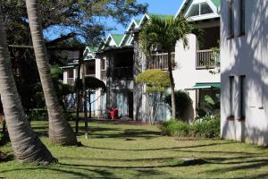 a row of houses with palm trees in the yard at 9 The Bridge Holiday Resort in St Lucia