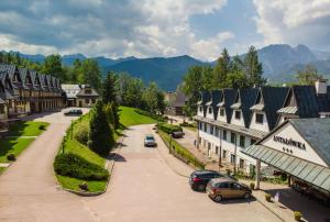 a street in a town with buildings and cars parked at Kompleks Antałówka Termy & Med in Zakopane +267 photos