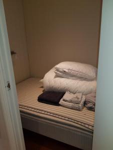 Una cama sin hacer con dos almohadas encima. en Apartment near the airport with ocean view, en Tromsø