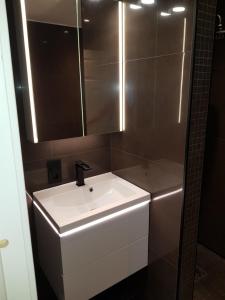 Un baño con un lavabo blanco y un espejo. en Apartment near the airport with ocean view, en Tromsø 13 fotos más