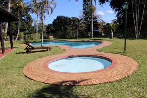 a small pool with a bench in a park at 62 The Bridge Holiday Resort in St Lucia