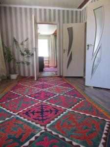un pasillo con una alfombra colorida en el suelo en "Bilim" Guest House, en Tamchy