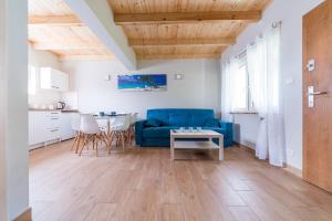 a living room with a blue couch and a table at Domki Lawendowe in Łeba