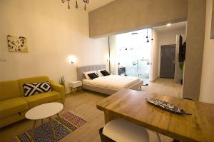 ein Wohnzimmer mit einem Sofa und einem Tisch in der Unterkunft Eshel Mansion - Boutique Suites in Be’er Scheva