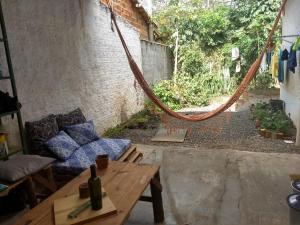 a living room with a couch and a hammock at Hospeda Vila in Vale do Capao