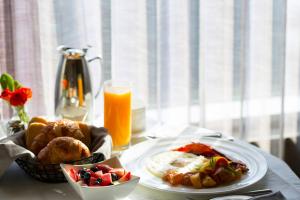 un tavolo con un piatto di cibo e un bicchiere di succo d'arancia di Fraser Suites Muscat a Mascate