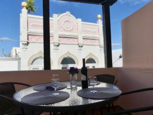 a table with a bottle of wine and two glasses at Kasa Sunshine in Olhão