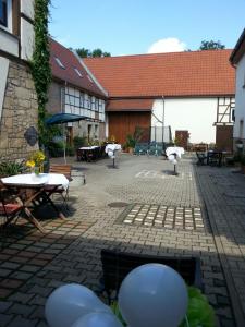 Landpension Gutshof Grossheringen في Großheringen: ساحة مع طاولات وكراسي ومبنى