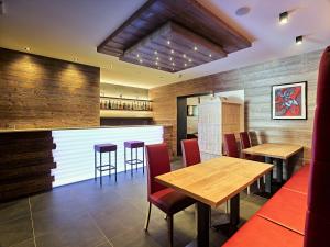 un restaurante con paredes de madera, mesas y sillas de madera en Hotel Garni Arnica ***S en Madonna di Campiglio