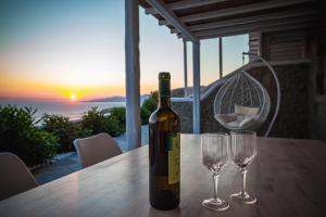 a bottle of wine sitting on a table with two wine glasses at Sugar Blue in Mýkonos City +47 photos
