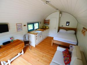 a bedroom with a bed and a couch in a room at Orchard Farm Luxury Glamping in Glastonbury