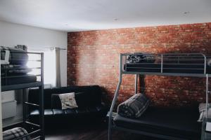 a room with two bunk beds and a brick wall at Taff Trail Bunkhouse in Merthyr Tydfil