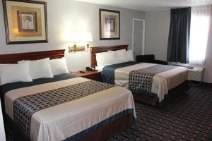 a hotel room with two beds and a window at The Lion Inn - Saint Augustine in Saint Augustine