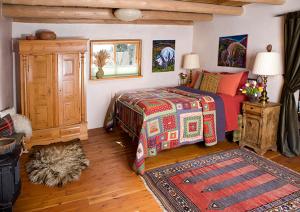 1 dormitorio con 1 cama, armario y alfombra en Casa Gallina - An Artisan Inn en Taos