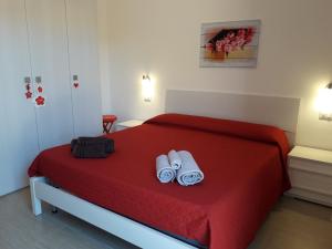 Un dormitorio con una cama roja con toallas. en Affittacamere b&b Il FIORE, en Posada