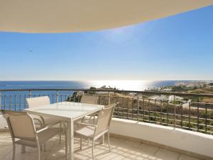 einen Balkon mit einem Tisch, Stühlen und Meerblick in der Unterkunft Olée Nerja Holiday Rentals by Fuerte Group in Torrox Costa