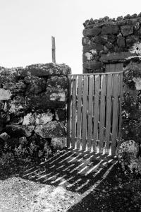 a gate in a stone wall next to a door at Vila Barca in Madalena