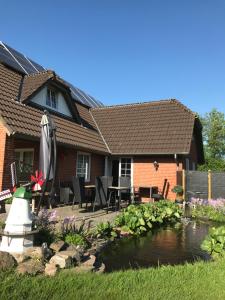 a house with a pond in the yard at SJ Rooms in Tønder