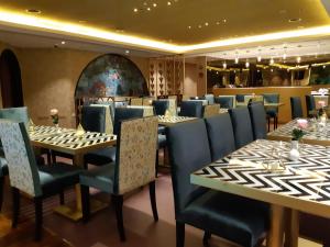 Lotus Grand Hotel في دبي: مطعم بطاولات طويلة وكراسي زرقاء