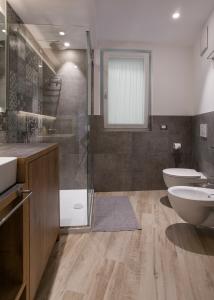 uma casa de banho com um WC, um lavatório e um chuveiro em Bellavista - Lake em Molveno