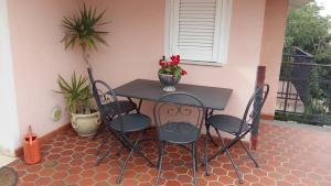 einen Tisch und Stühle auf einer Terrasse mit Pflanzen in der Unterkunft Appartamento in villa in Su Forti