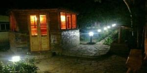 a house with lights on the side of it at night at L'a Dacha in Tamga
