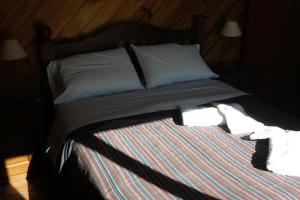 Una cama con dos almohadas y dos toallas encima. en Cabañas Bahía Marina, en El Calafate 13 fotos más