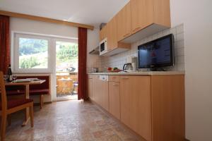 eine Küche mit einem TV, einem Tisch und einem Fenster in der Unterkunft Karlspitze -Natur Pur Appartementhaus in Kaunertal