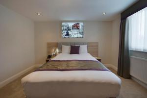 Un dormitorio con una cama grande y una ventana en OYO Townhouse 30 Sussex Hotel, London Paddington en Londres
