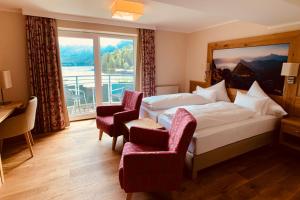 pokój hotelowy z łóżkiem i dużym oknem w obiekcie Seevilla Altaussee w mieście Altaussee