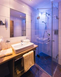 a bathroom with a sink and a shower at Hotel Sonnleiten in Ladis