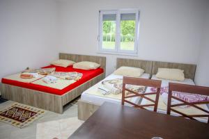 two beds in a room with two chairs and a window at Apartments River Una 4 in Bihać