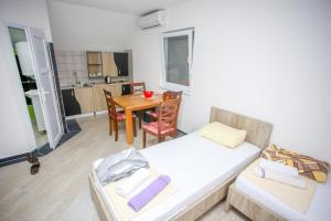 a room with two beds and a table and a kitchen at Apartments River Una 4 in Bihać +17 photos