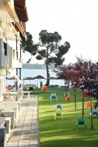 a group of benches on the grass next to a building at Haus Platanos Apartments & Bungalows by the Sea in Vourvourou
